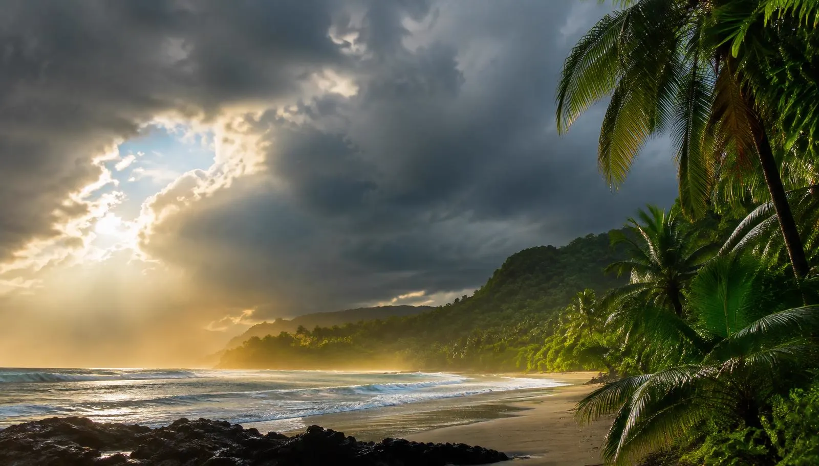 Green-season storm clouds with sunlight over a tropical beach